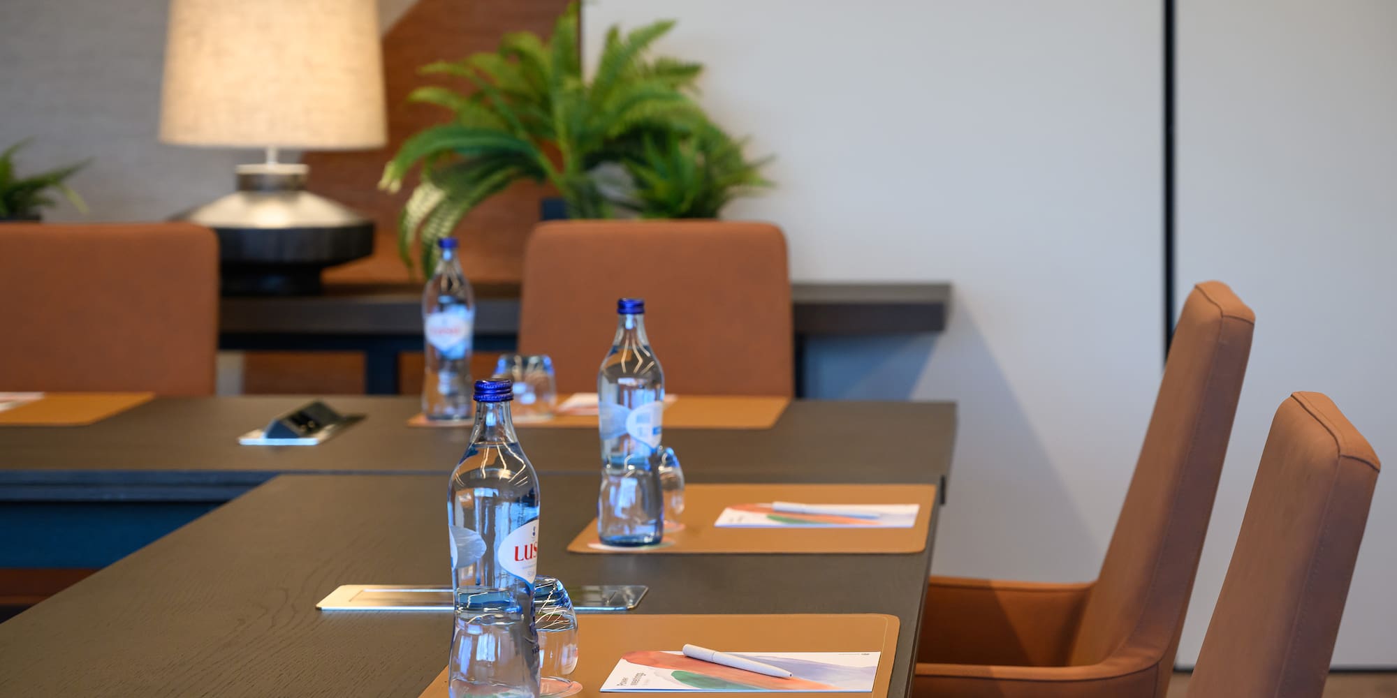 a table with water bottles and place mats