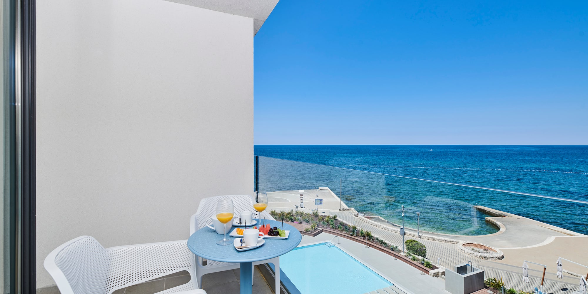 a table and chairs on a balcony overlooking a body of water