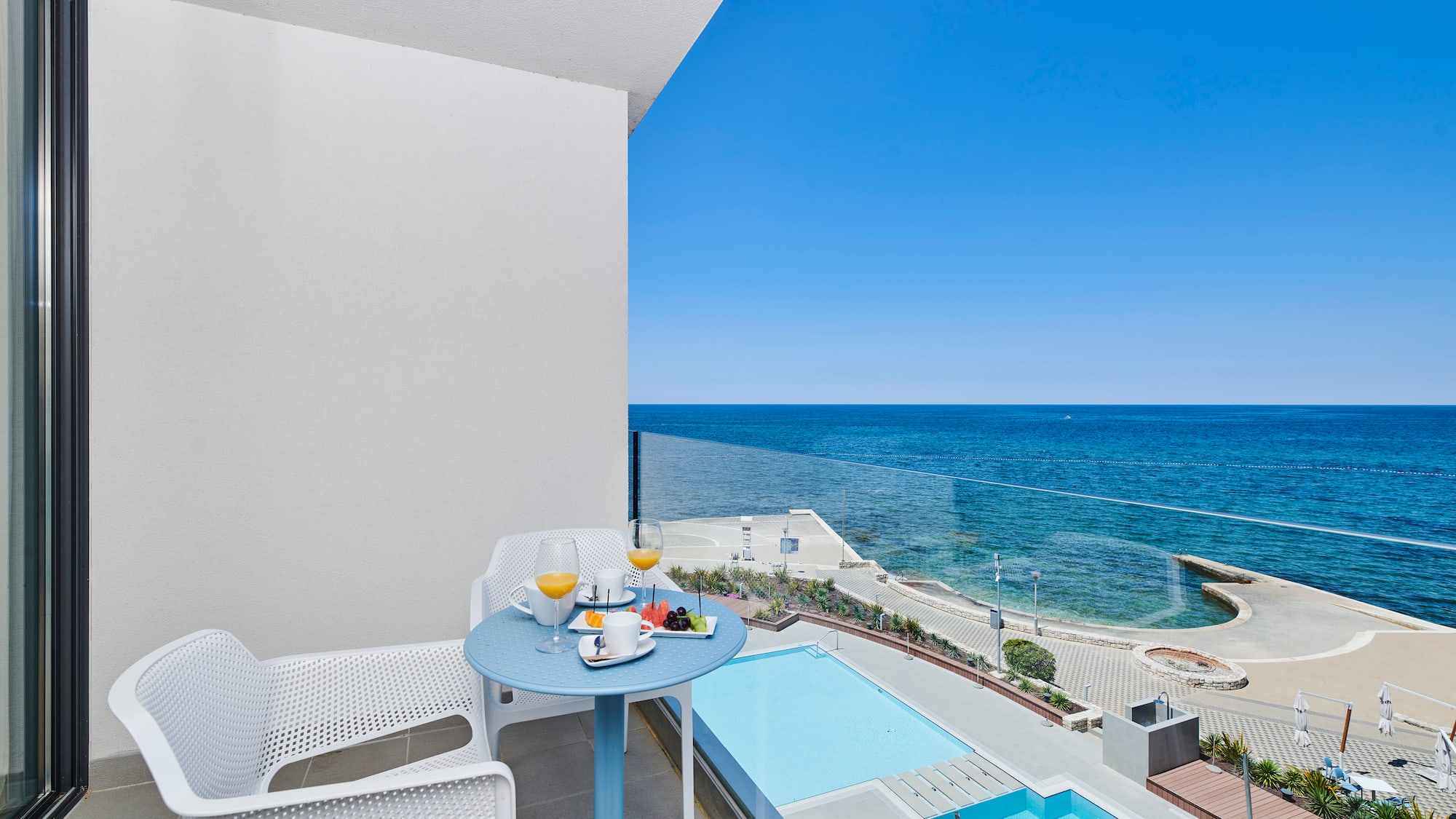 a table and chairs on a balcony overlooking a body of water