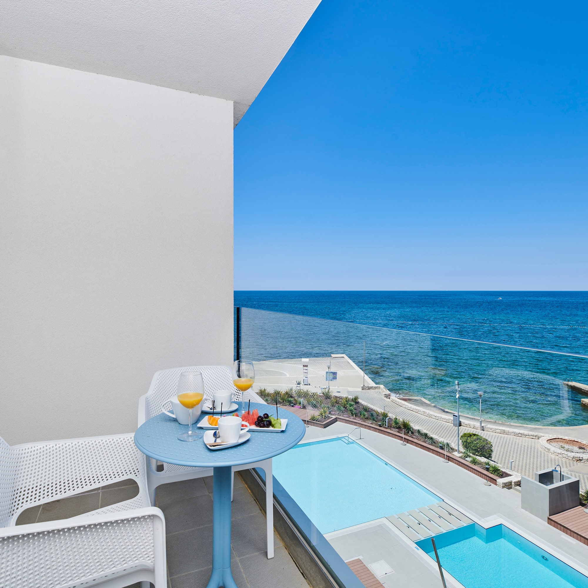 a table and chairs on a balcony overlooking a body of water