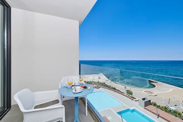 a table and chairs on a balcony overlooking a body of water