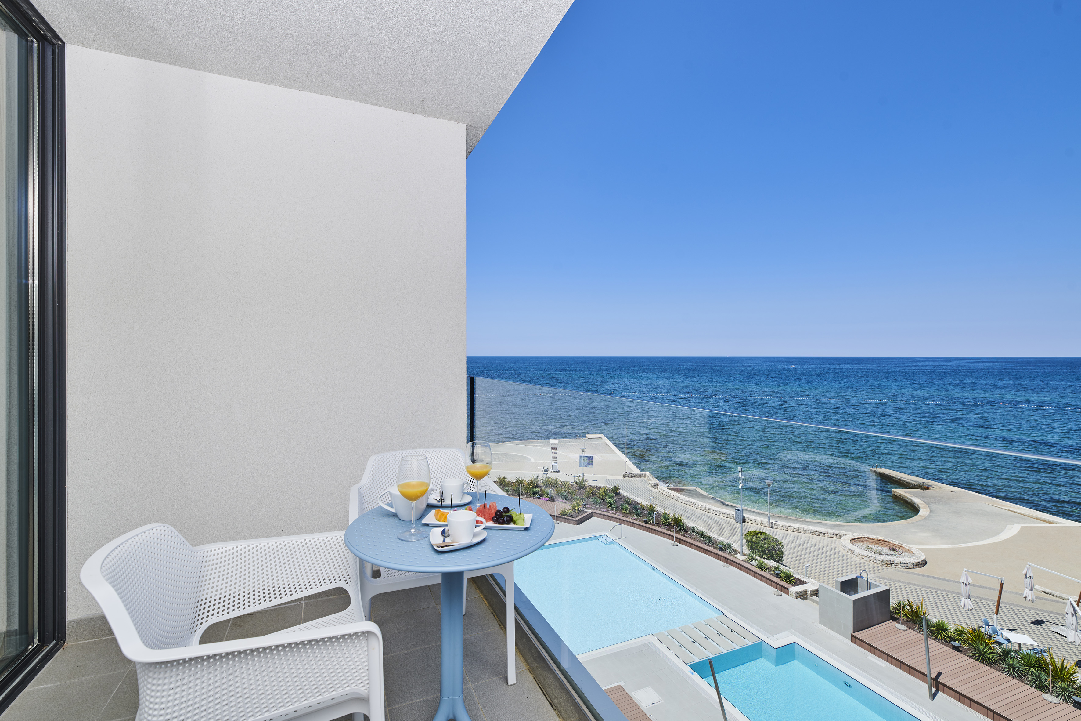 a table and chairs on a balcony overlooking a body of water