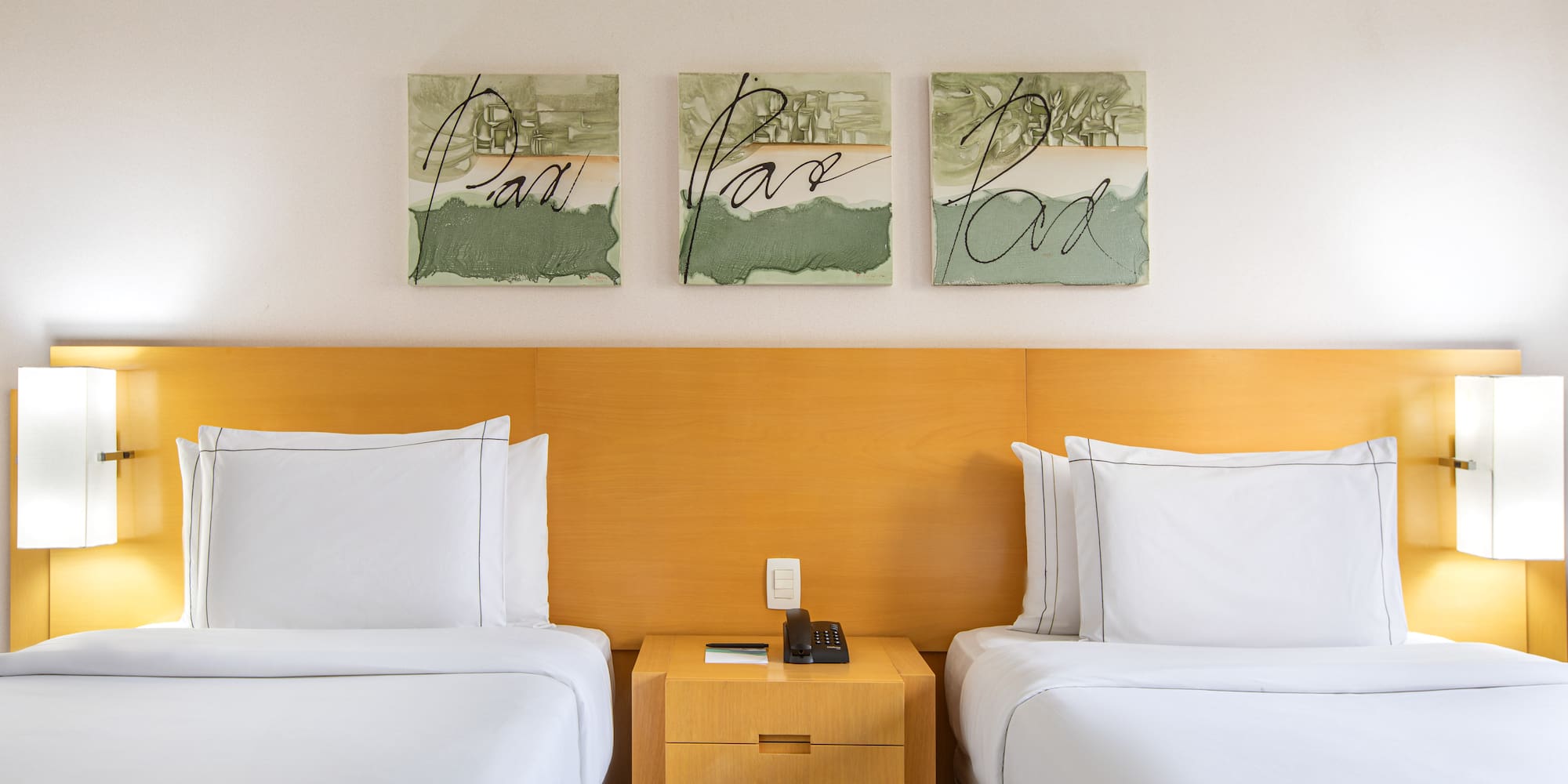 two beds with white sheets and a nightstand