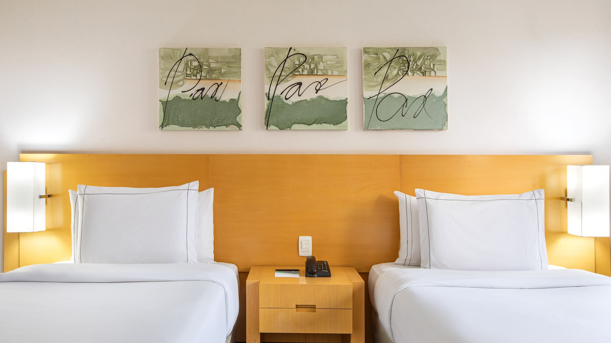 two beds with white sheets and a nightstand