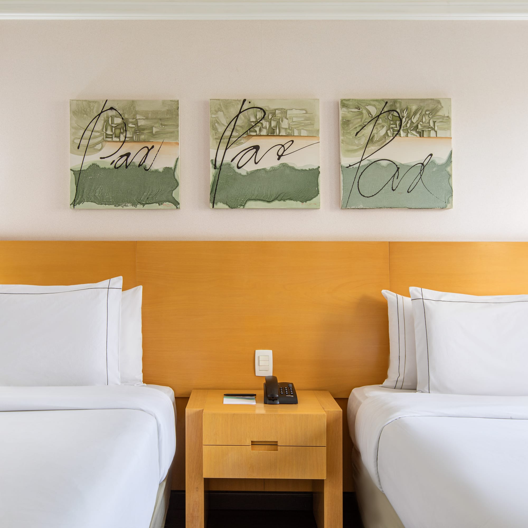 two beds with white sheets and a nightstand