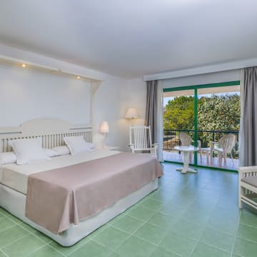 a bedroom with a bed and chairs.