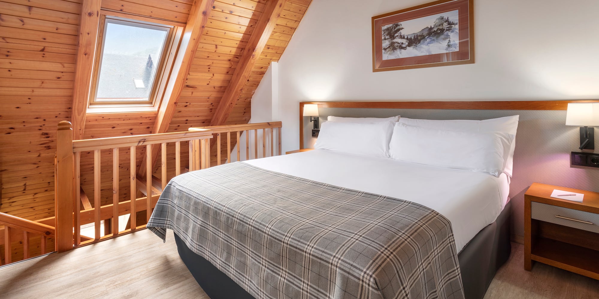 a bed in a room with a wood ceiling and a picture on the wall