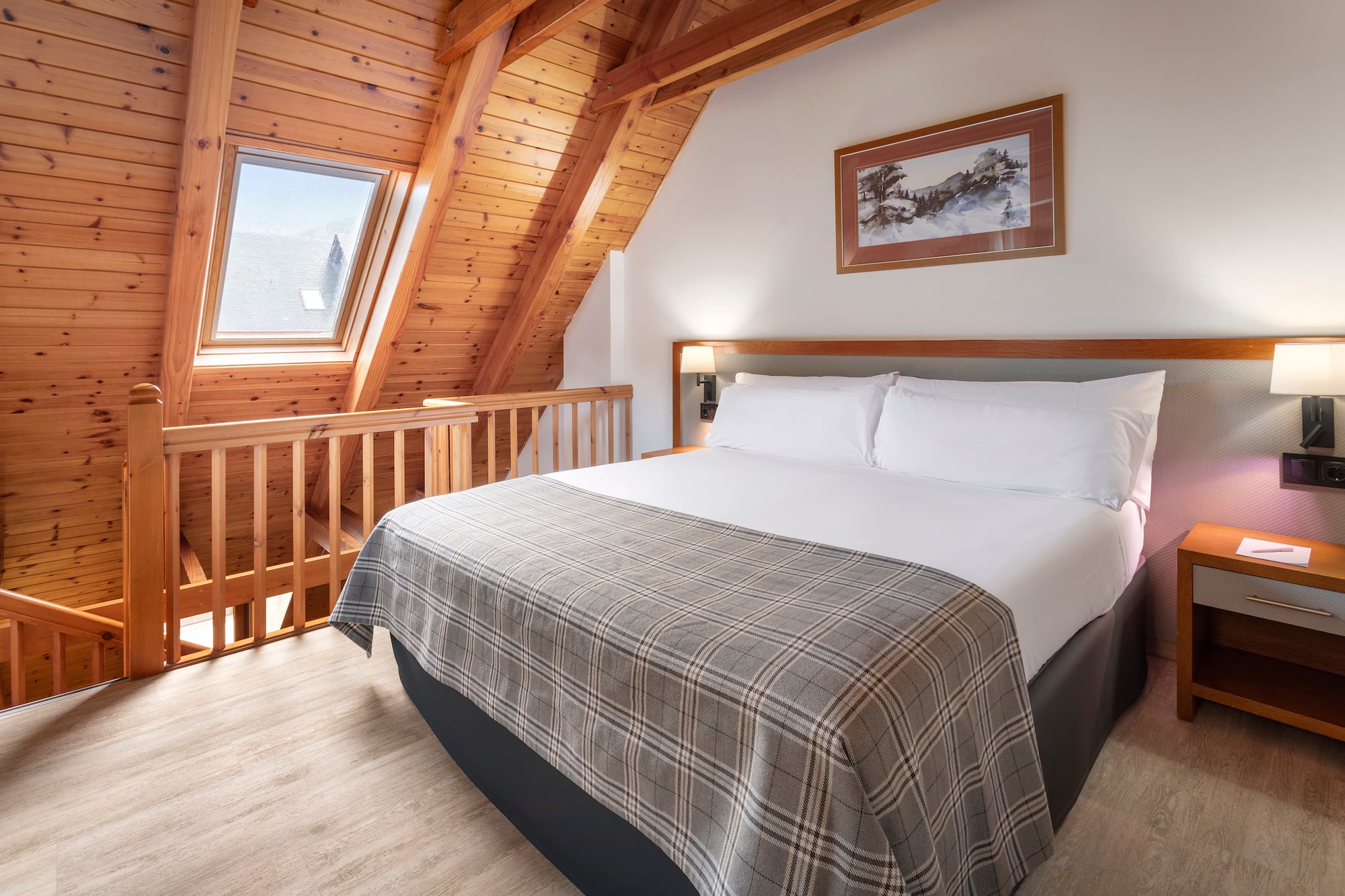 a bed in a room with a wood ceiling and a picture on the wall