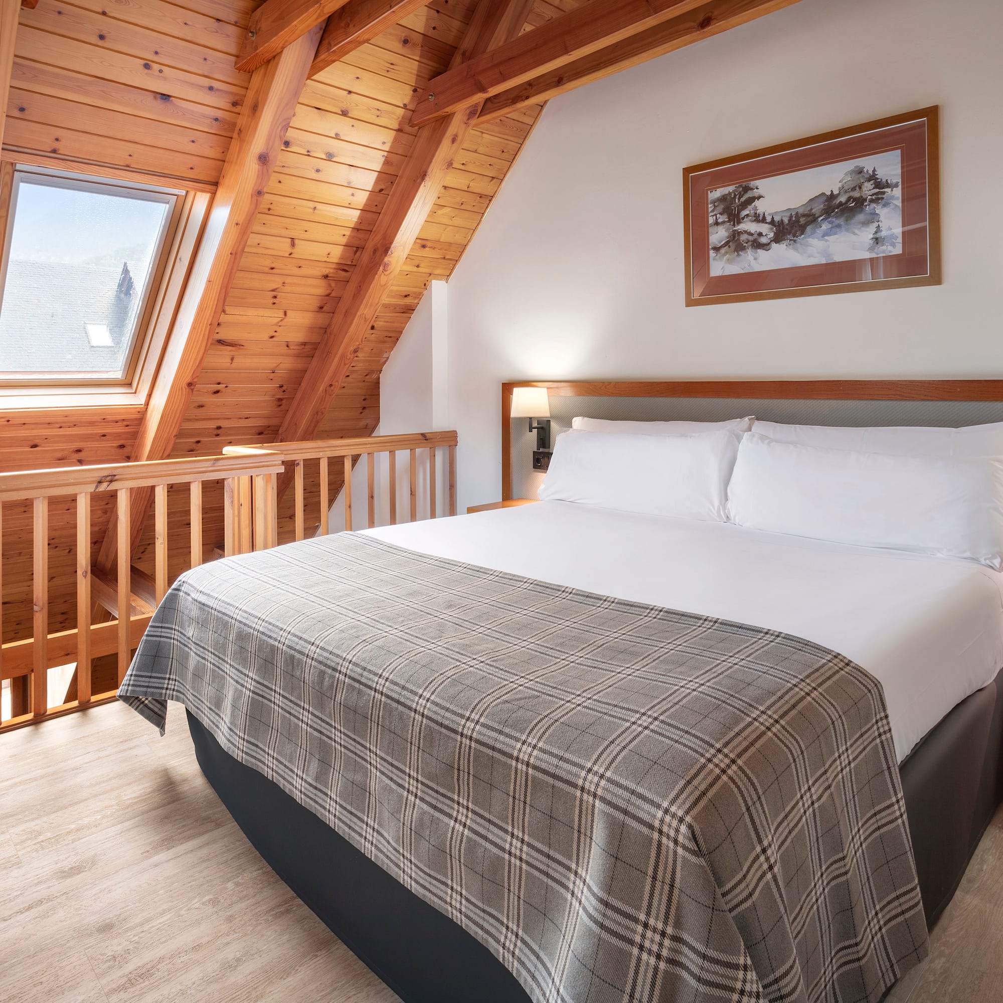 a bed in a room with a wood ceiling and a picture on the wall