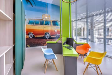 a room with a computer and colorful chairs
