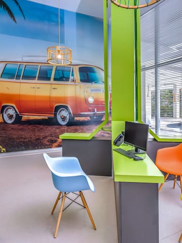 a room with a computer and colorful chairs