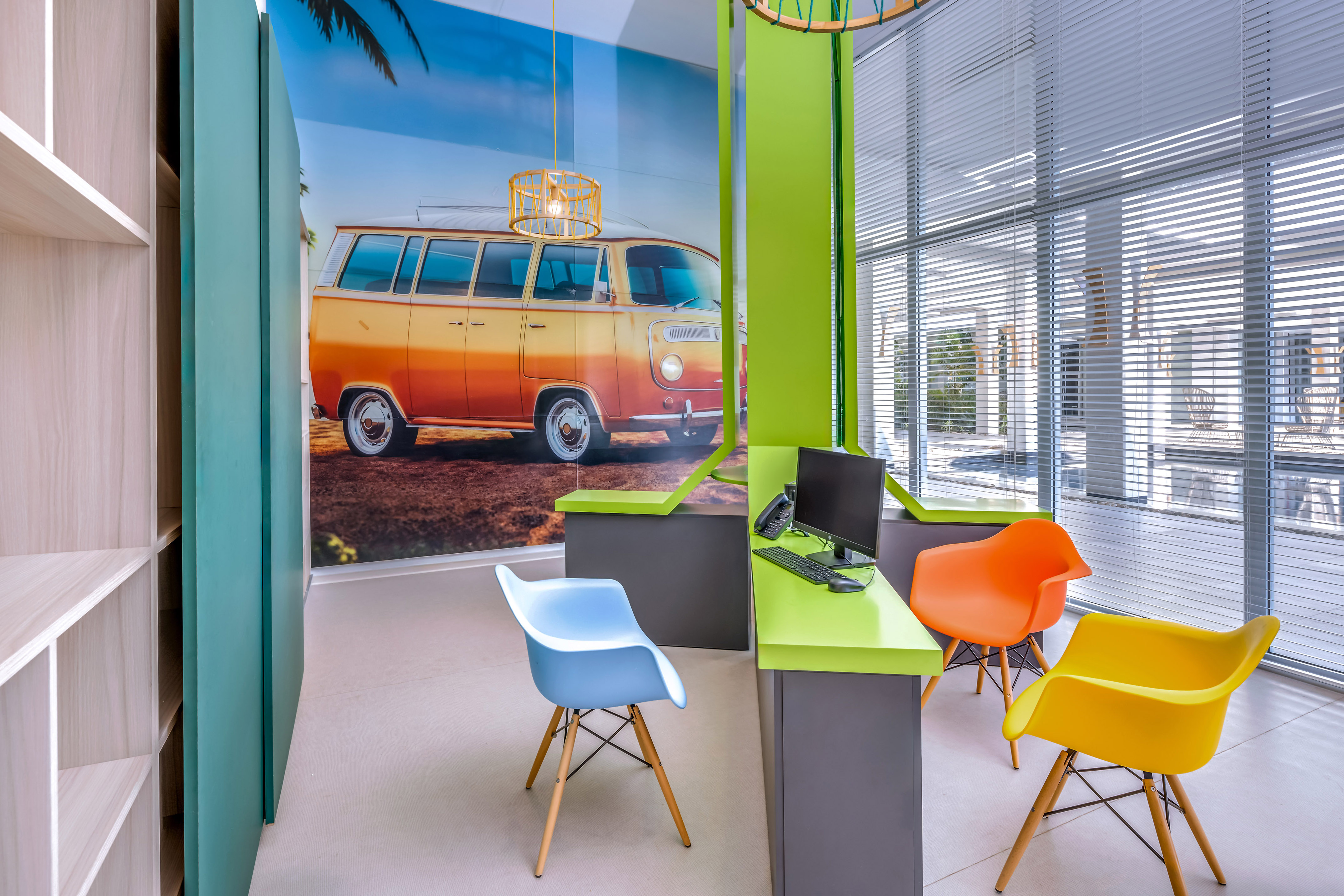 a room with a computer and colorful chairs