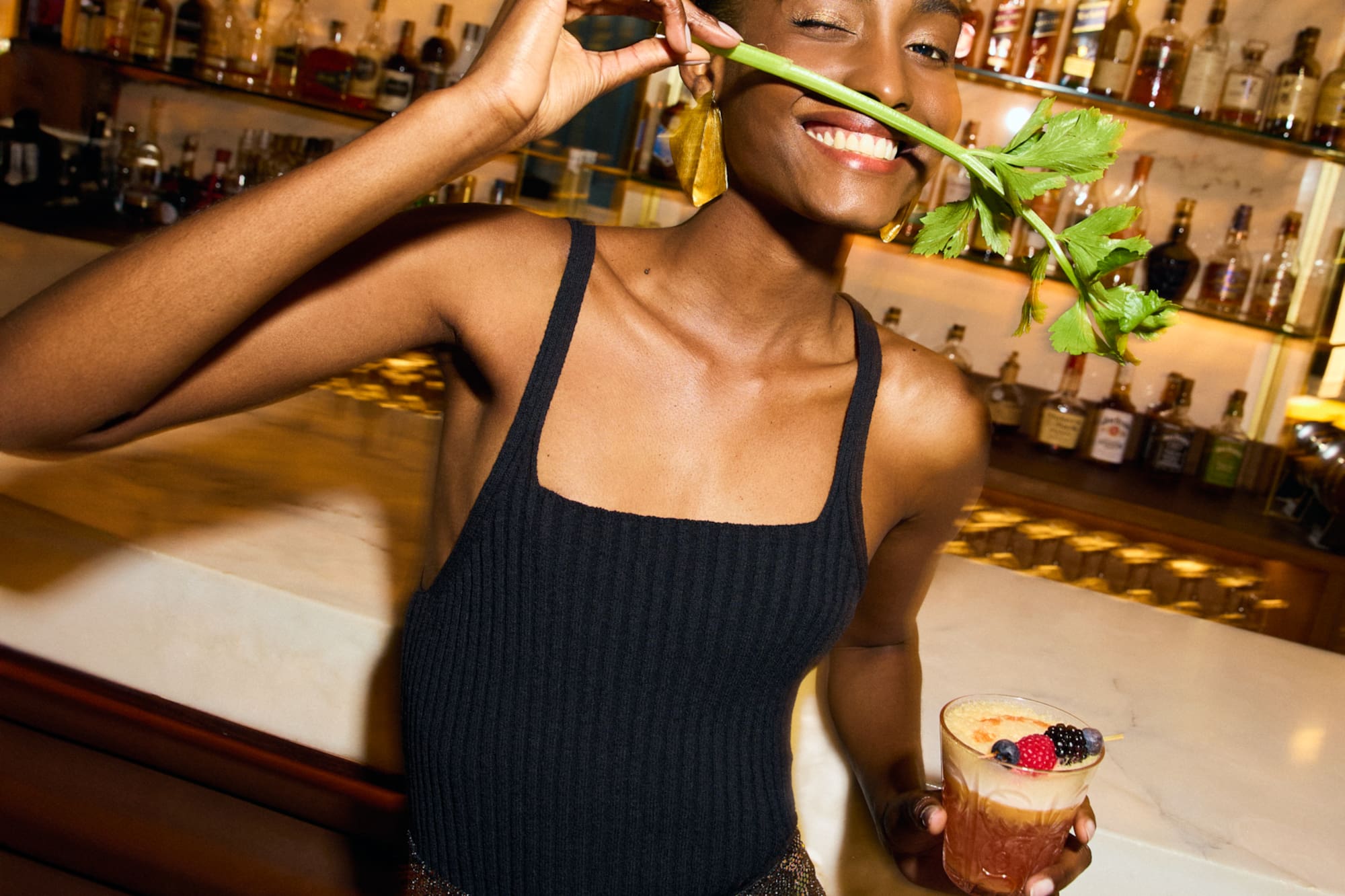 a woman holding a stem in her mouth and holding a drink