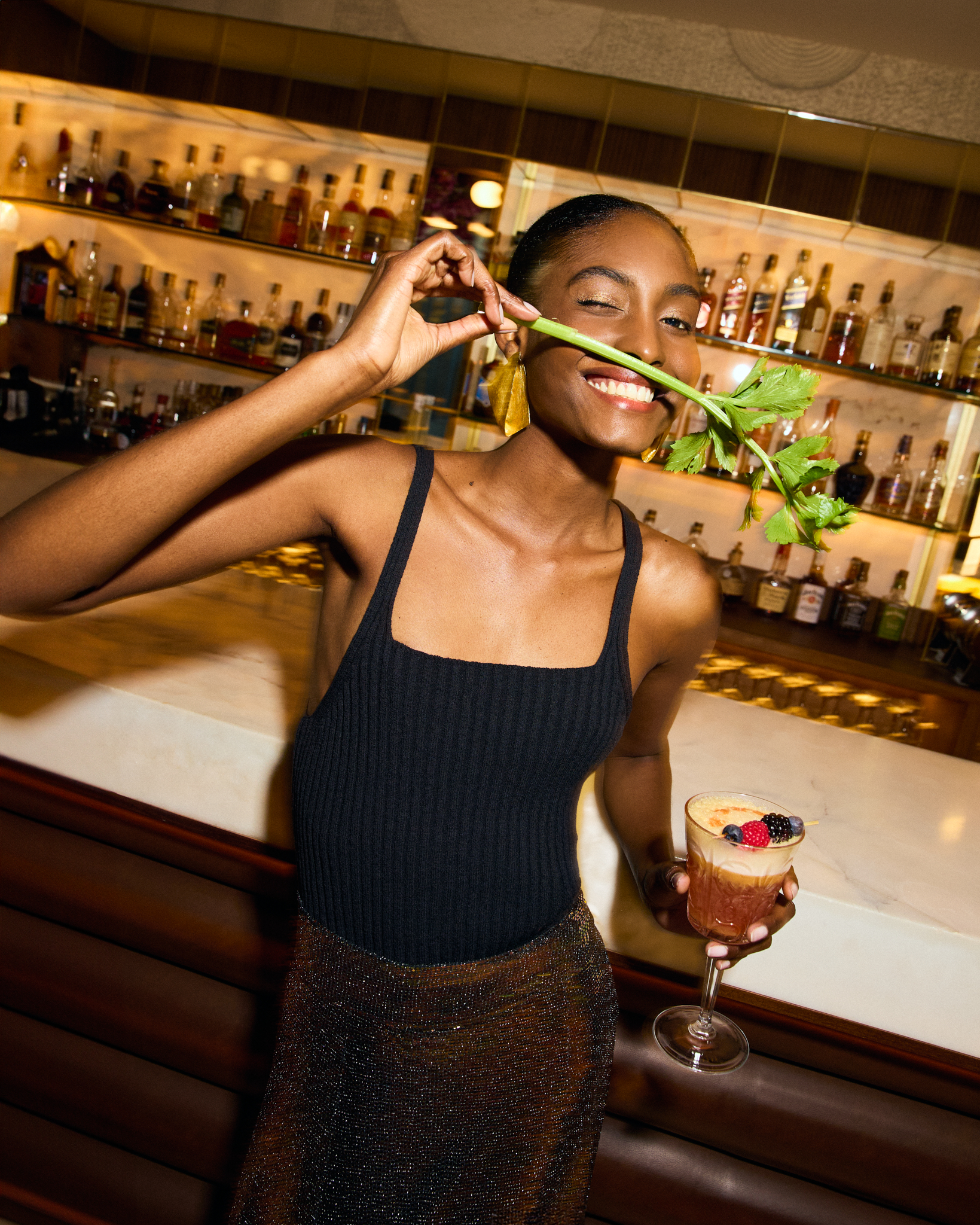 a woman holding a stem in her mouth and holding a drink