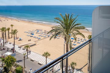 a beach with palm trees and umbrellas