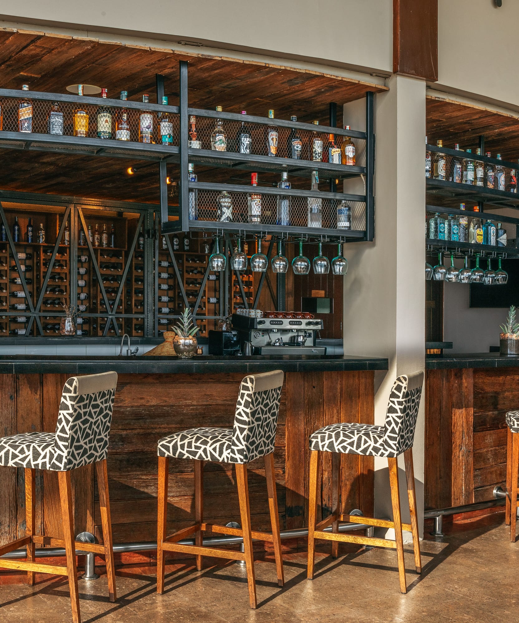 a bar with chairs and shelves in front of it