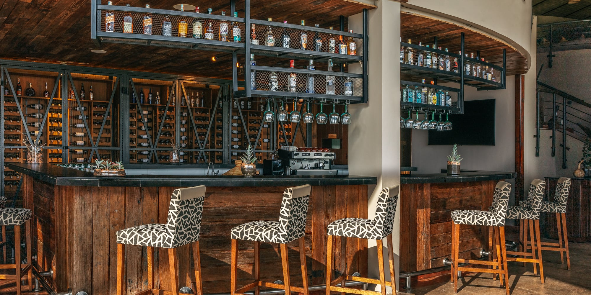 a bar with chairs and shelves in front of it