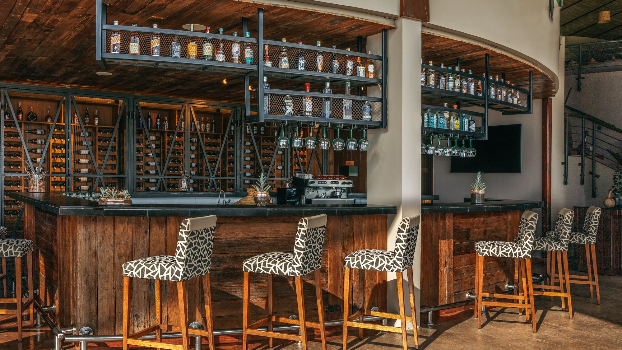 a bar with chairs and shelves in front of it