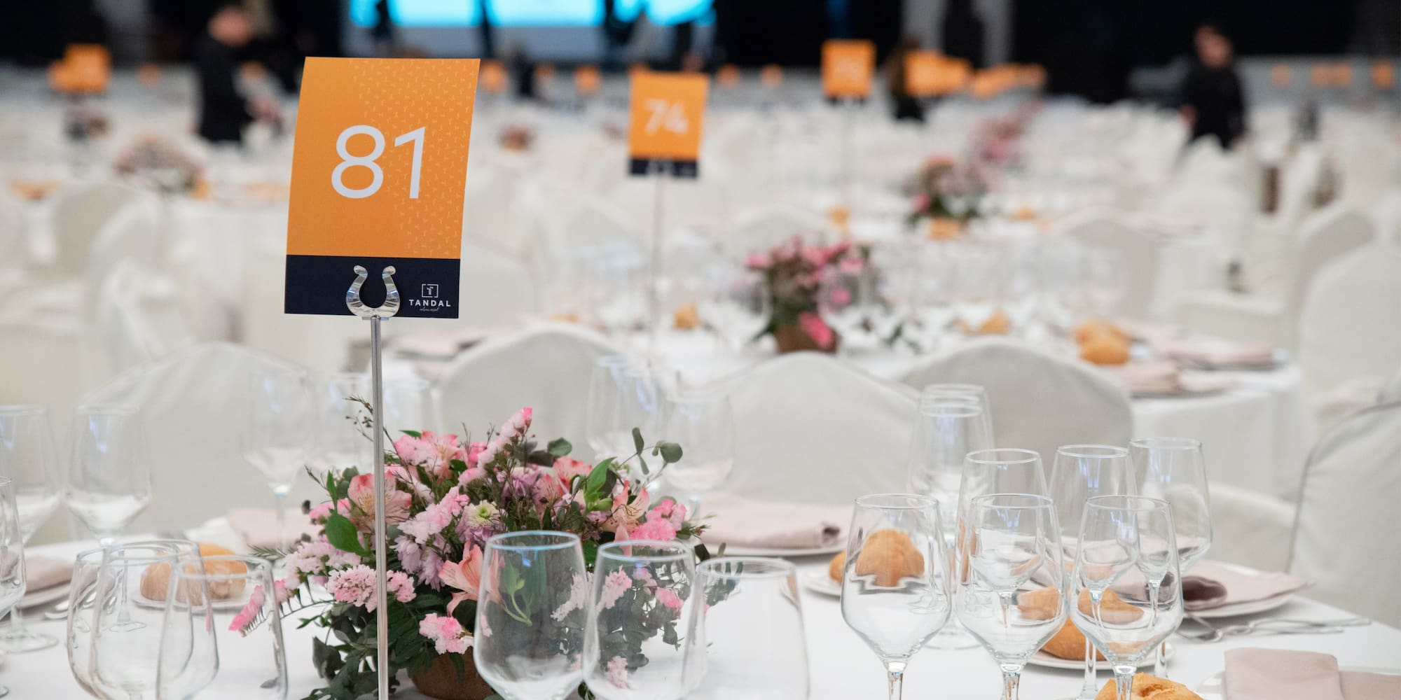a table set with wine glasses and flowers