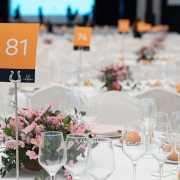 a table set with wine glasses and flowers