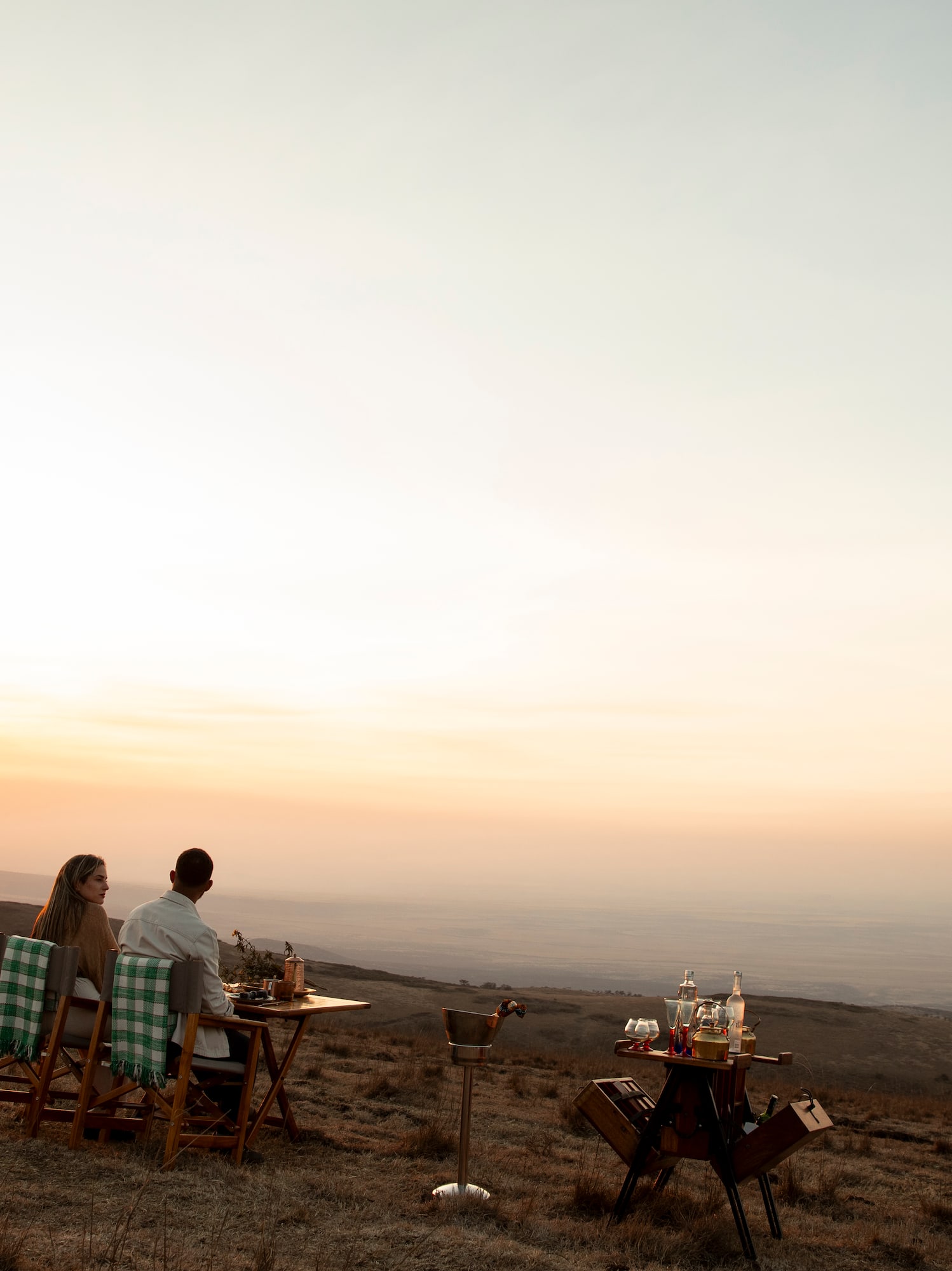 Cena romántica de pareja en la montaña al atardecer, paisaje africano.