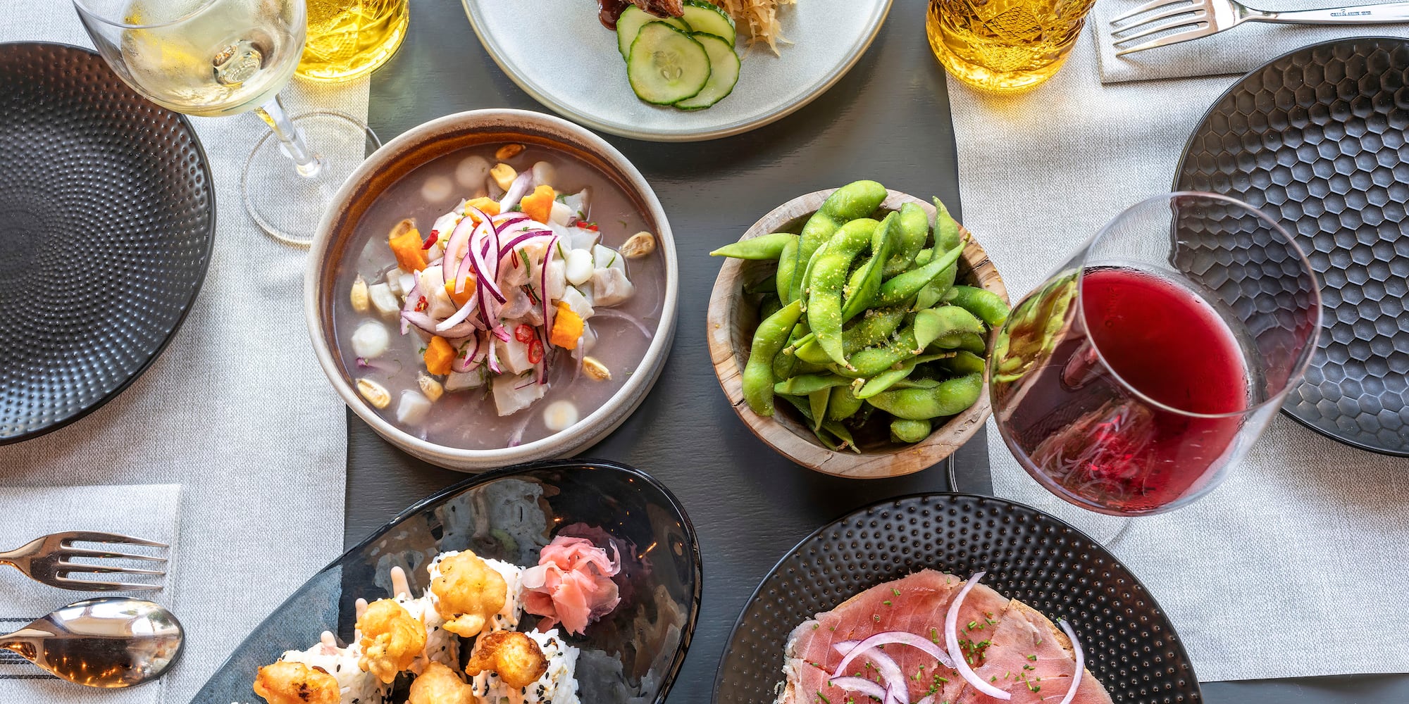 a table with plates of food and glasses of wine