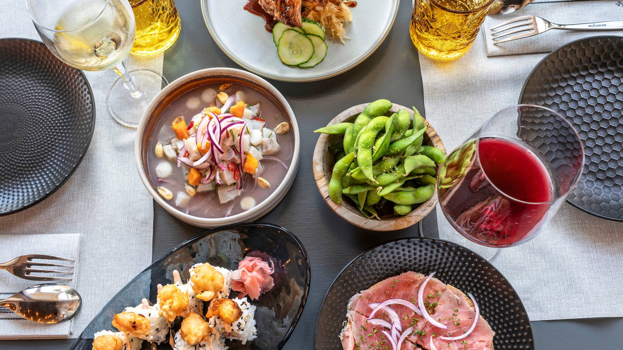a table with plates of food and glasses of wine