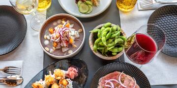 a table with plates of food and glasses of wine
