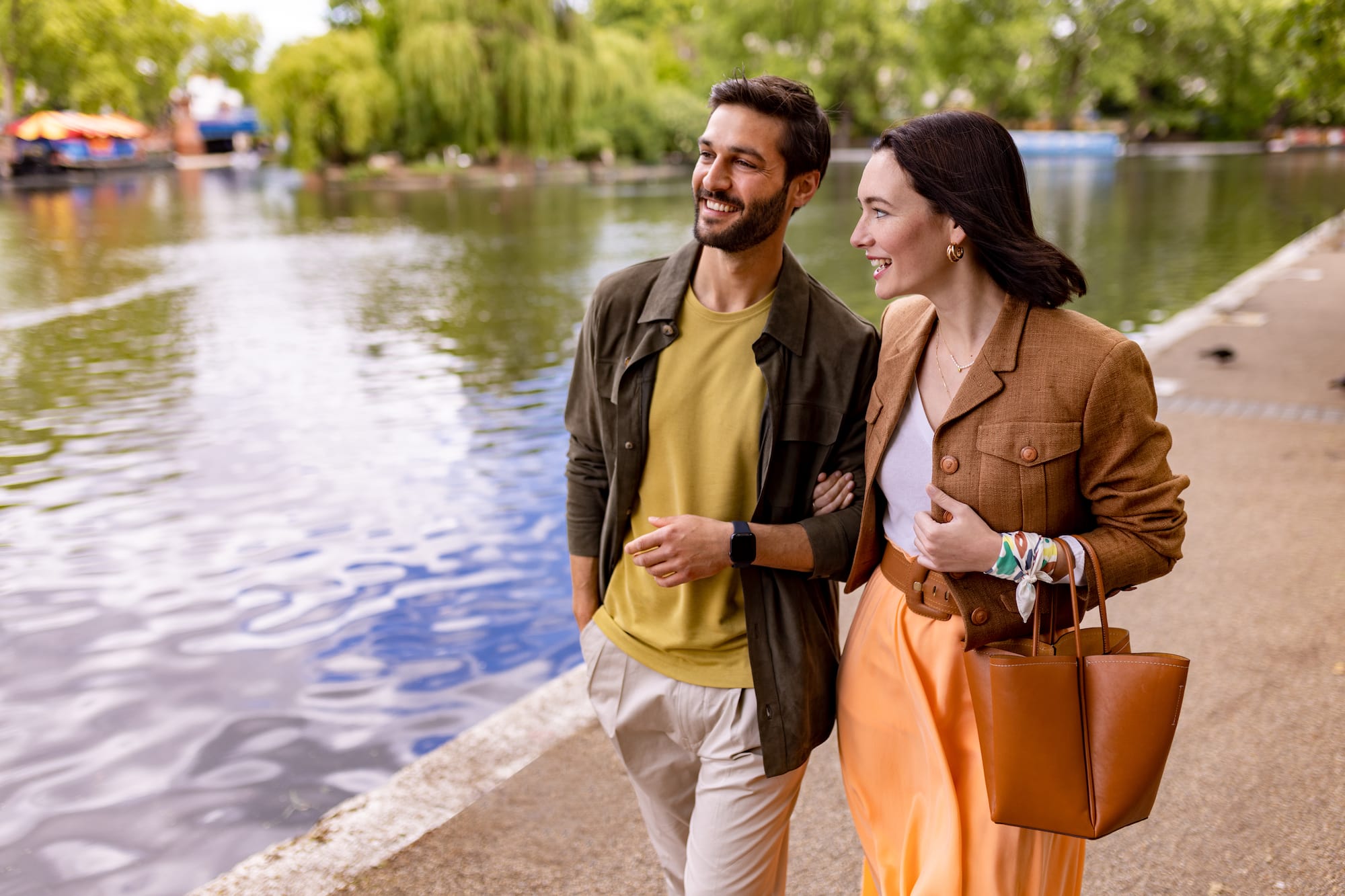 a man and woman walking by a lake