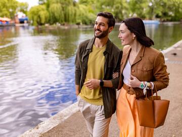 a man and woman walking by a lake