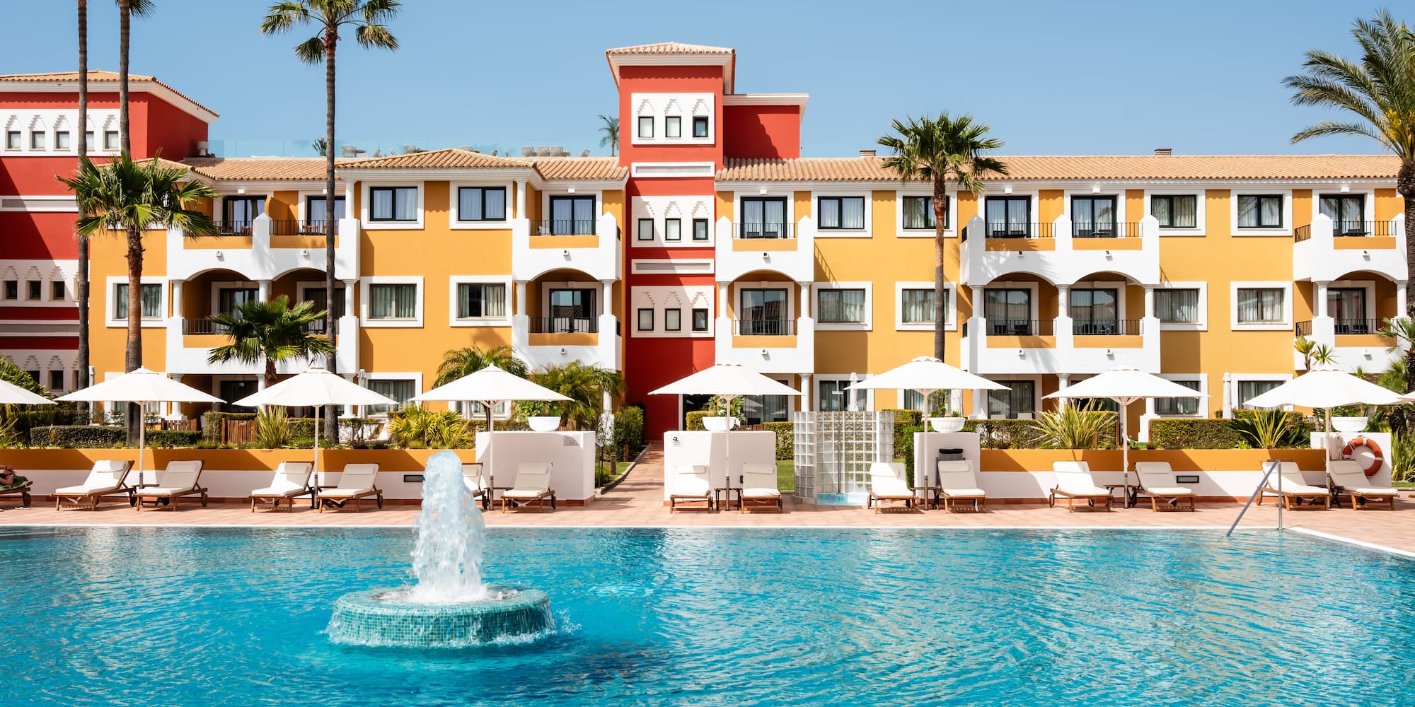 a pool with a fountain in front of a building