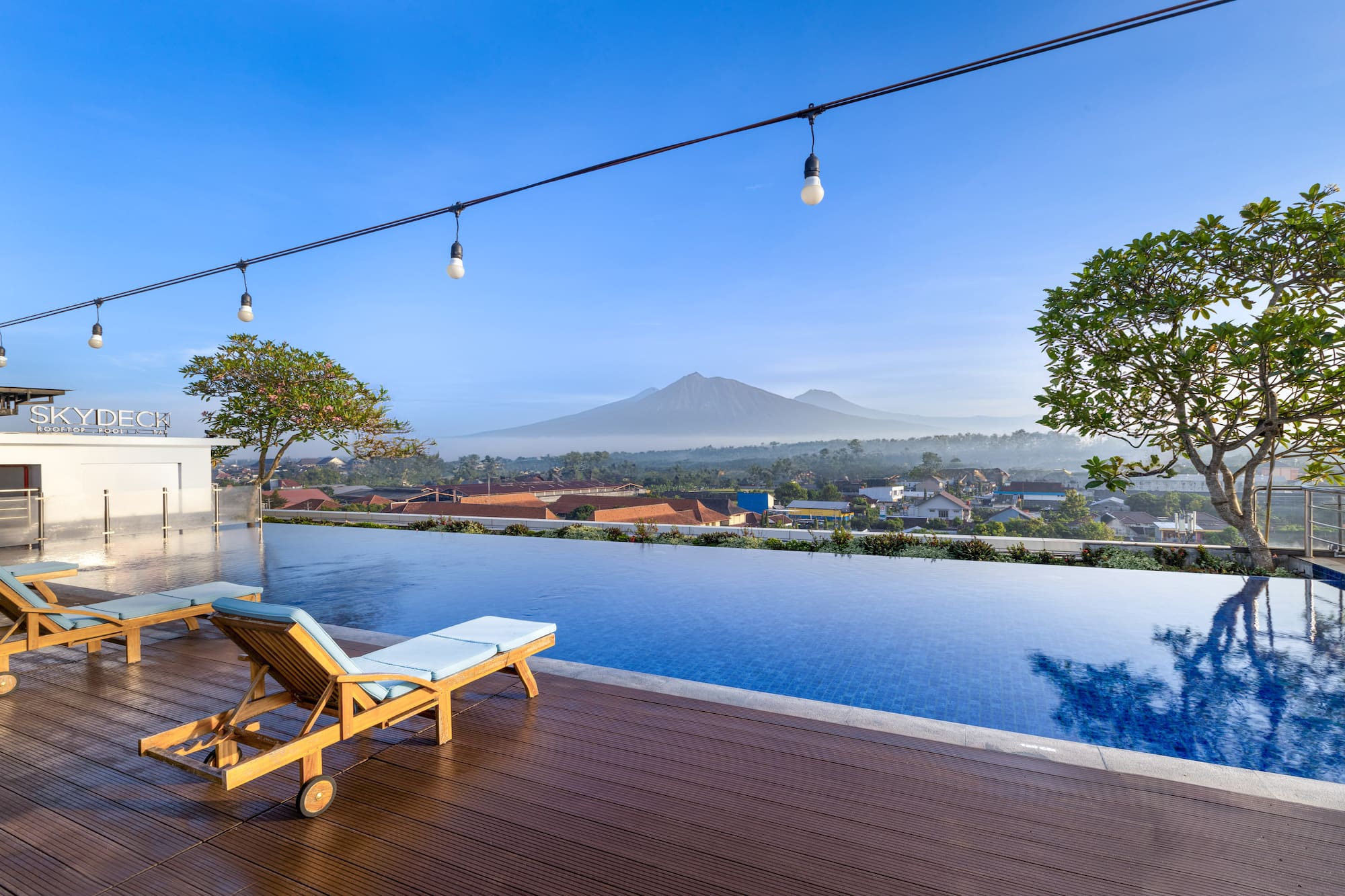 a pool with a deck chair and a mountain in the background