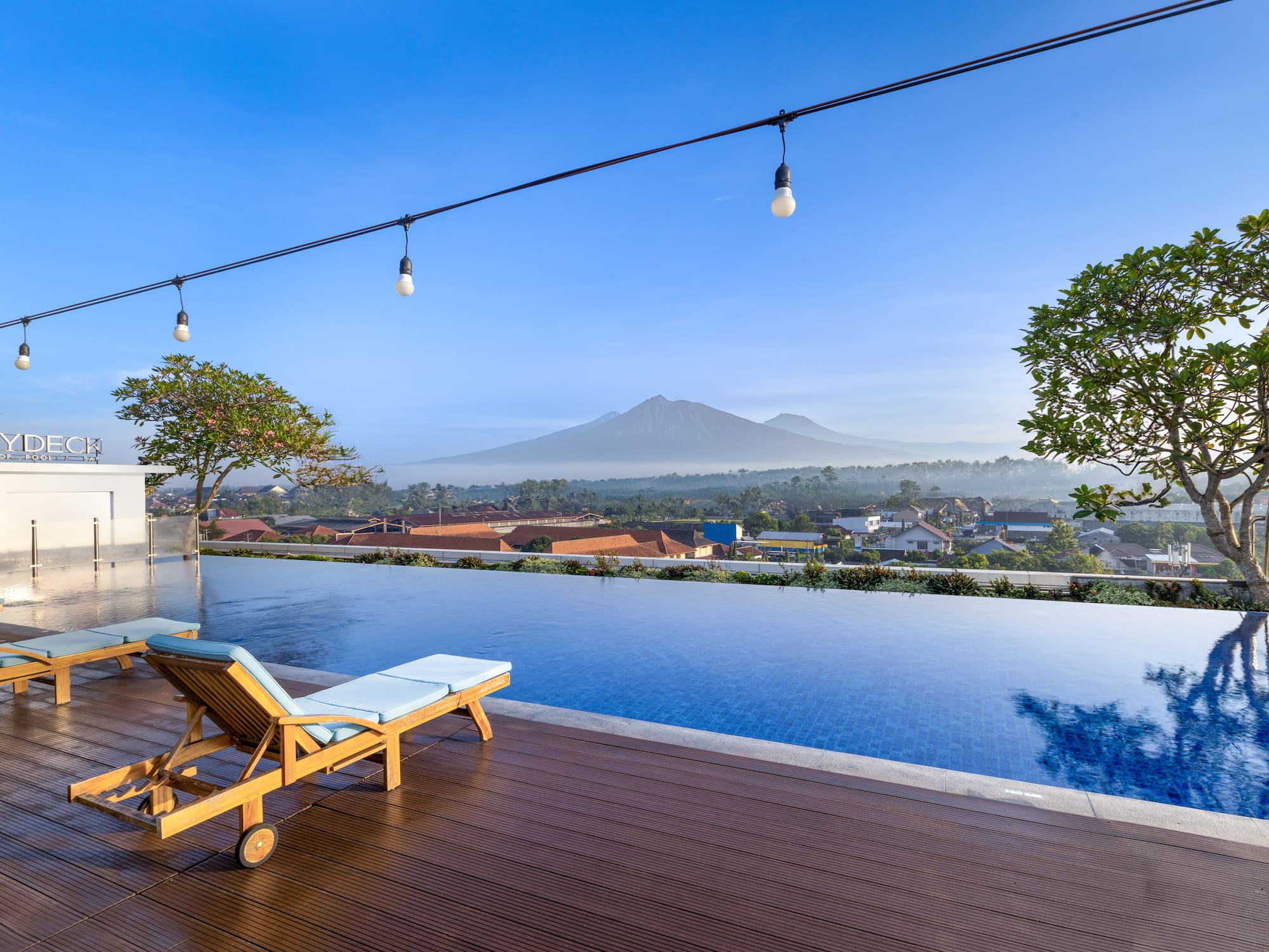 a pool with a deck chair and a mountain in the background