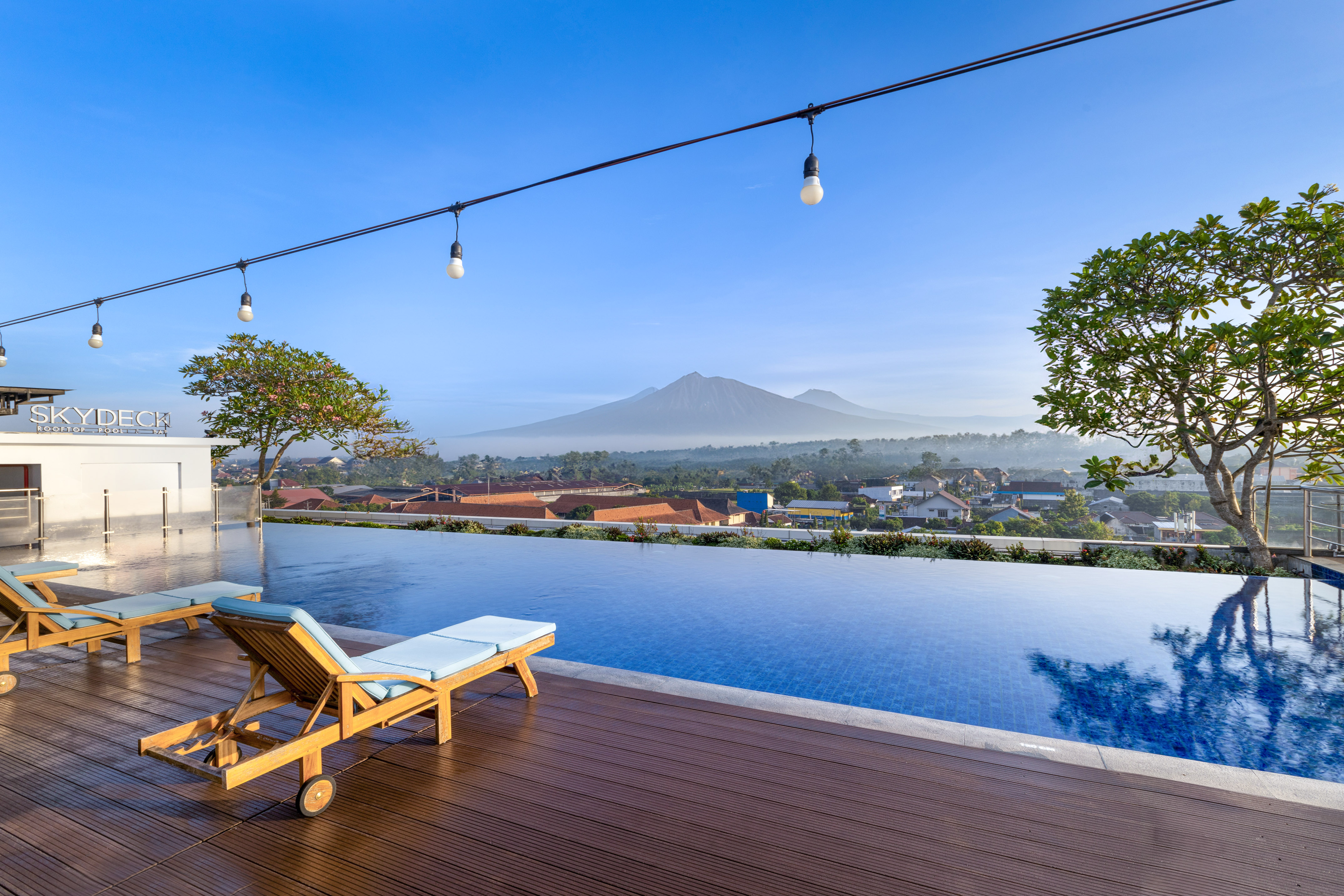 a pool with a deck chair and a mountain in the background.
