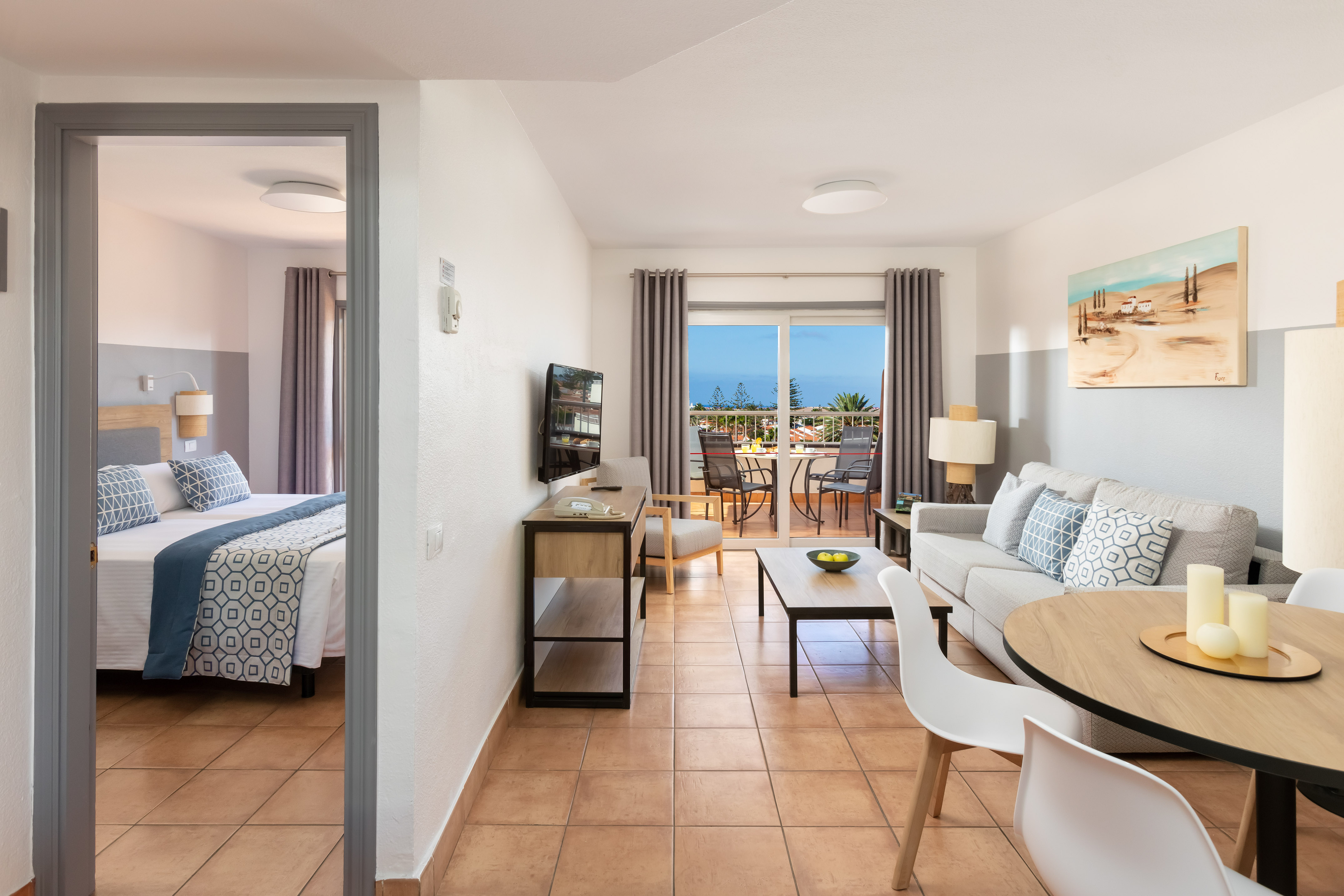 Bright apartment with living room, bedroom, dining, and balcony with ocean view.