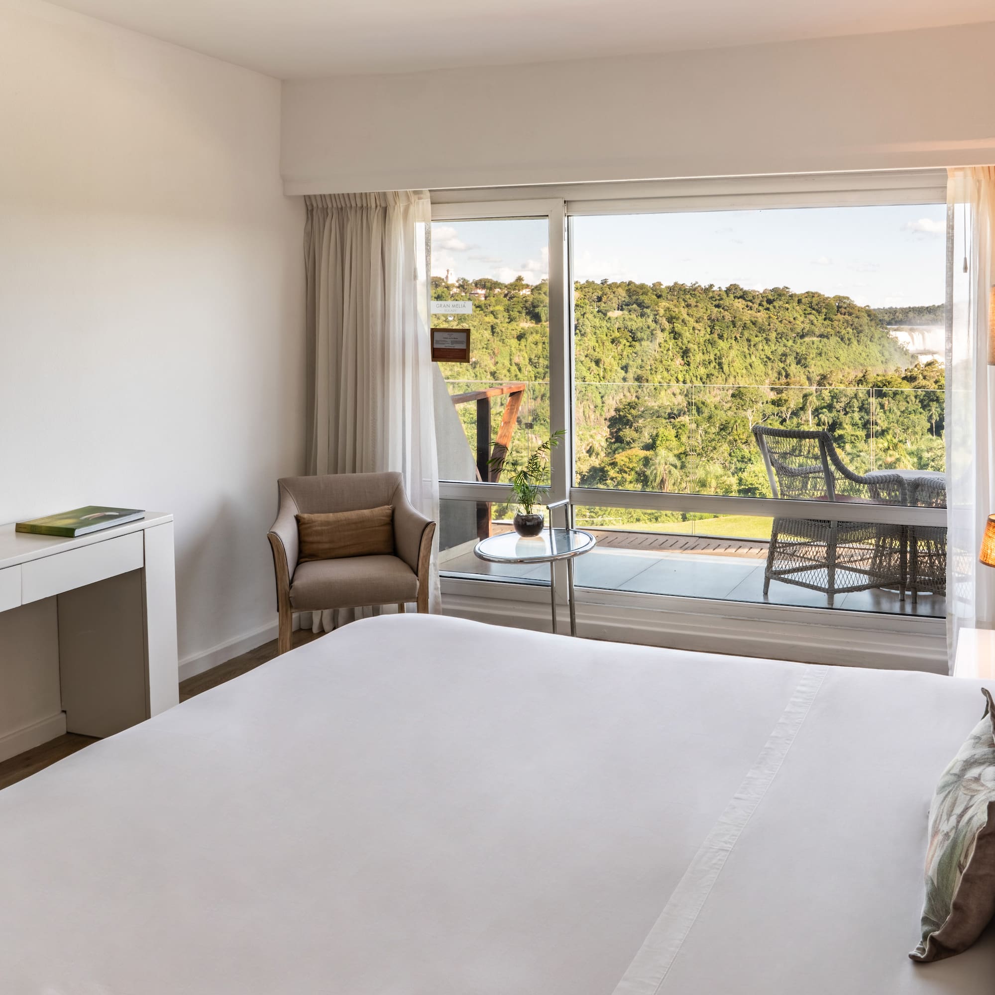 a bedroom with a large window and a view of the forest