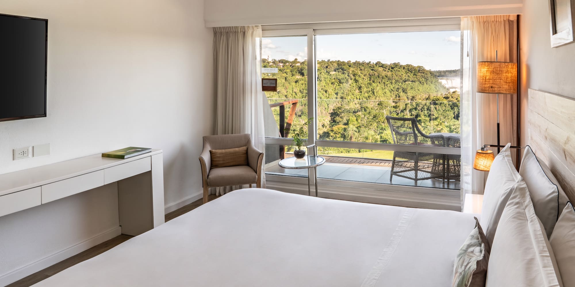 a bedroom with a large window and a view of the forest