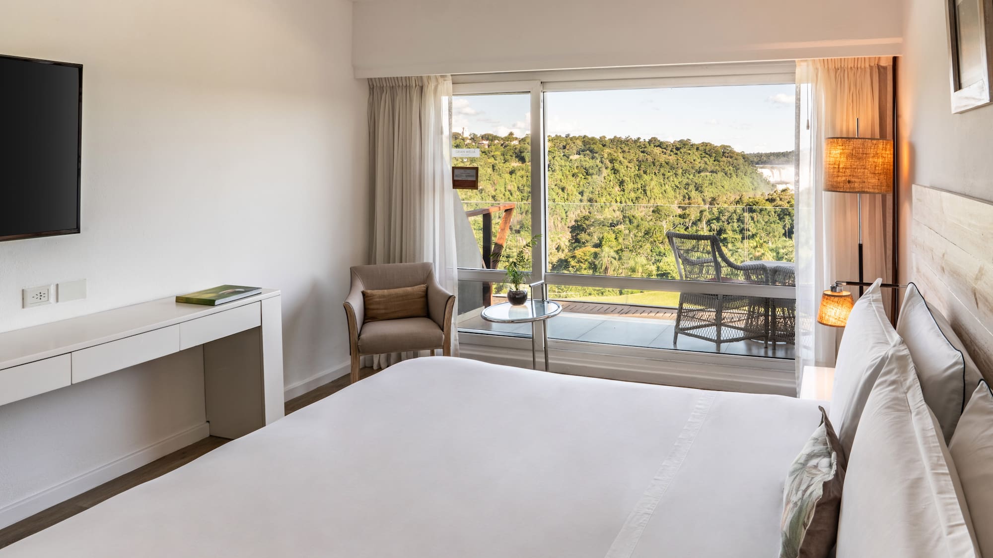 a bedroom with a large window and a view of the forest