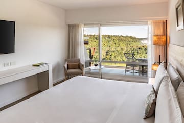 a bedroom with a large window and a view of the forest