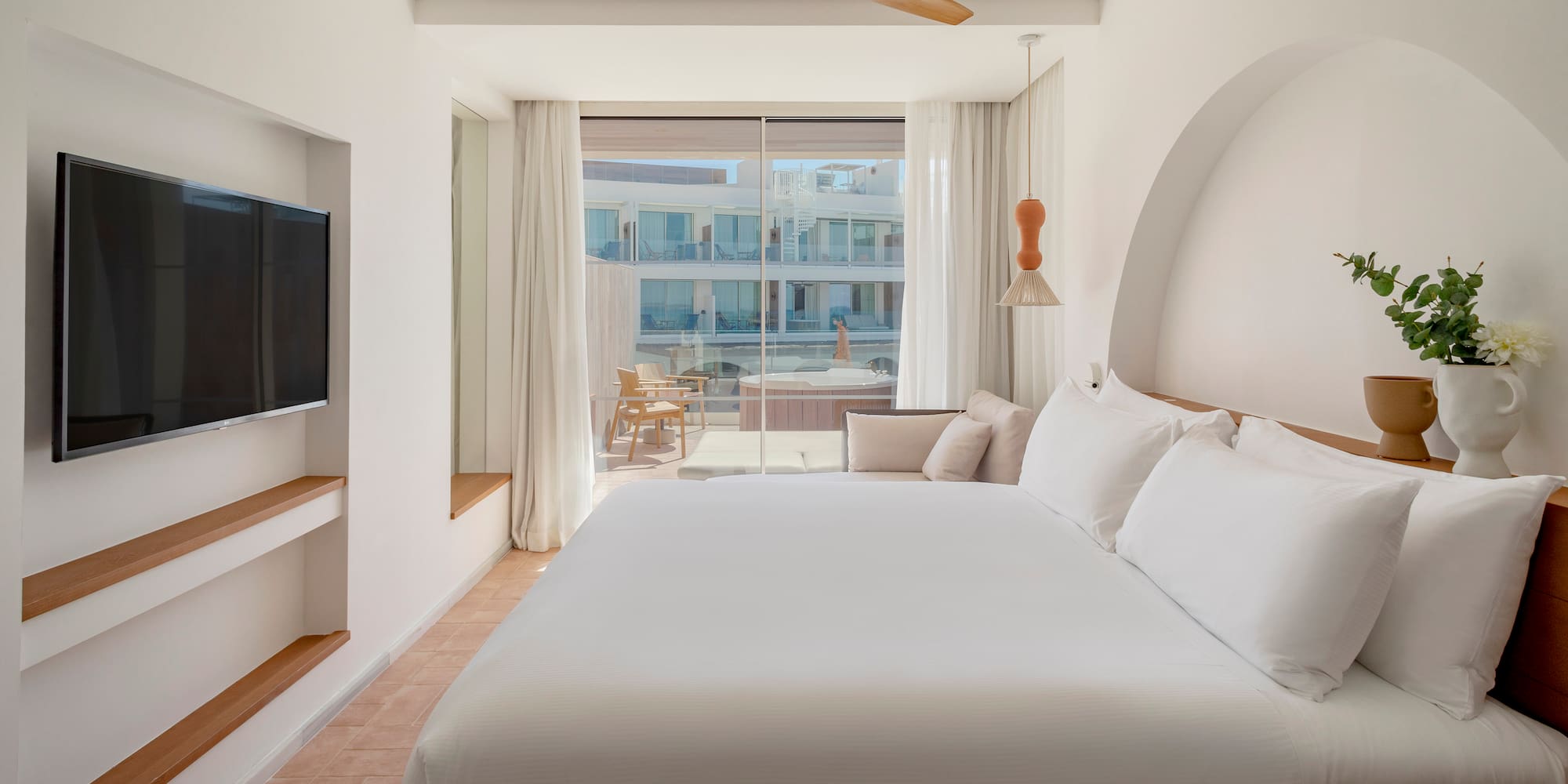 a bed in a room with a television and a ceiling fan