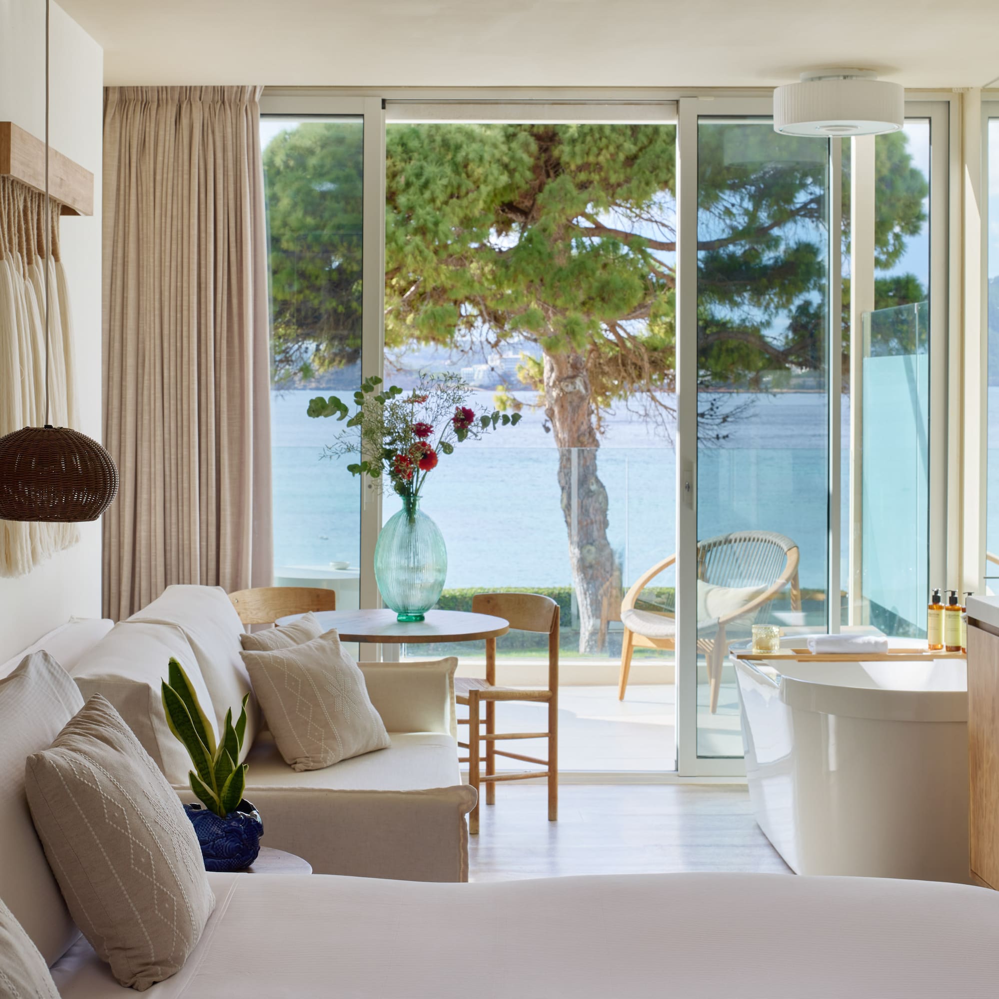 a room with a tub and a bathtub and a tub with a view of the water