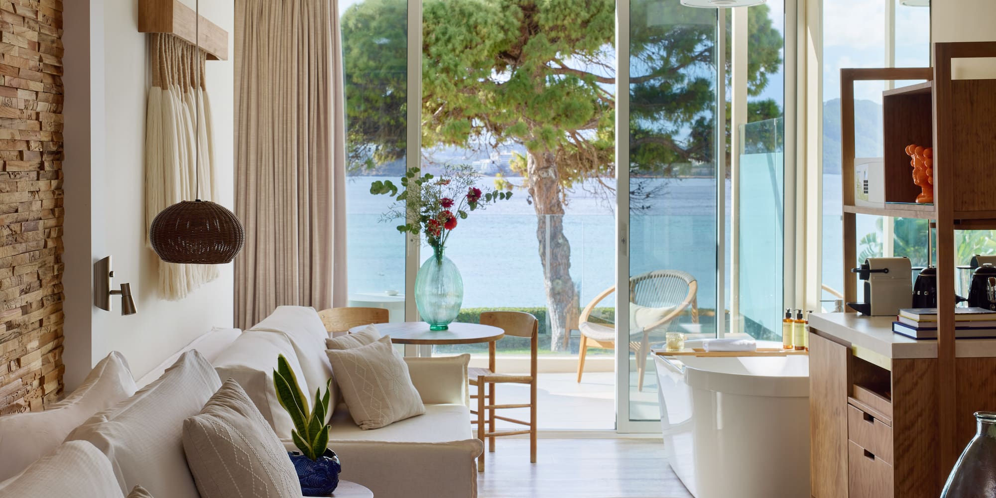 a room with a tub and a bathtub and a tub with a view of the water