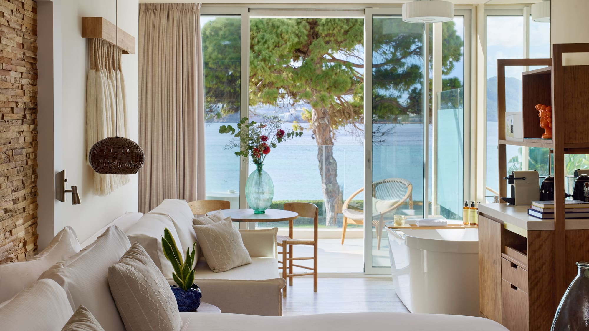 a room with a tub and a bathtub and a tub with a view of the water