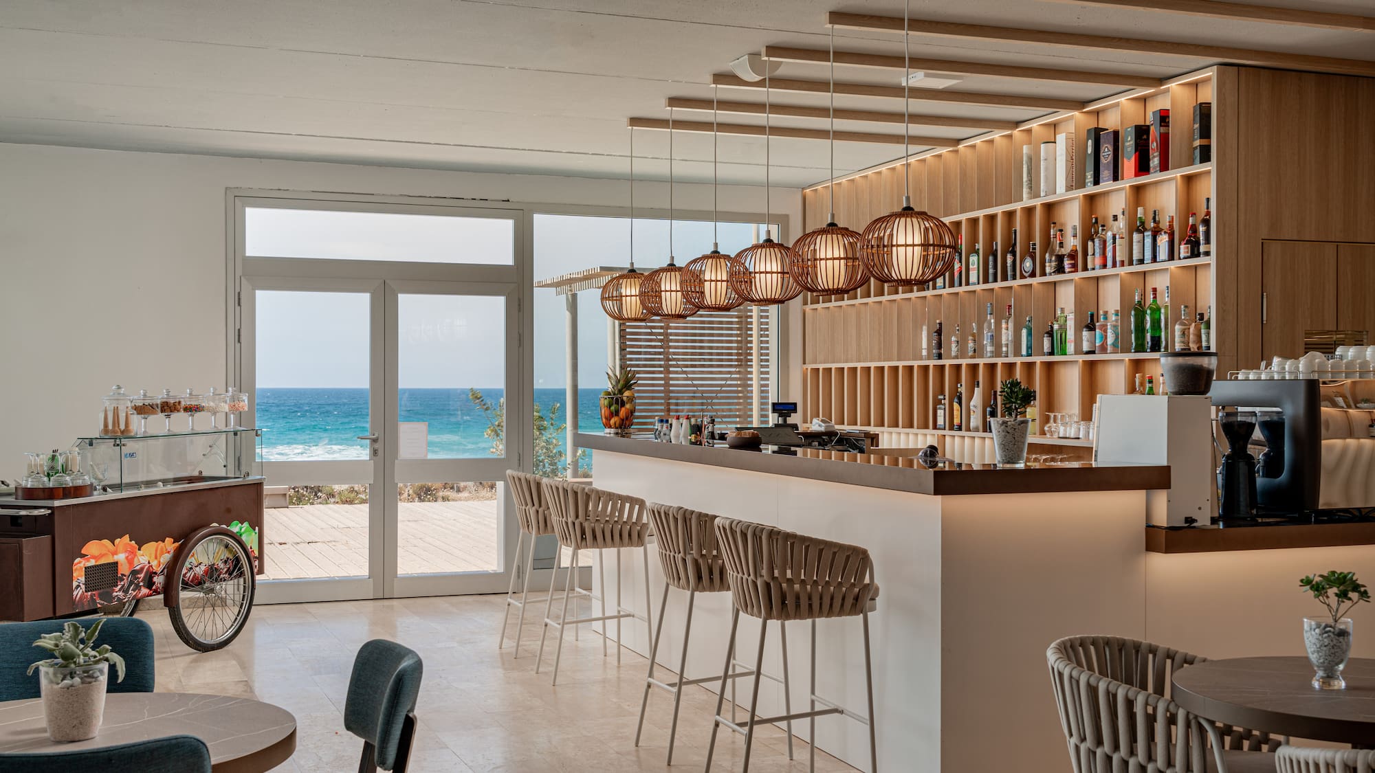 a bar with chairs and a shelf with bottles on it