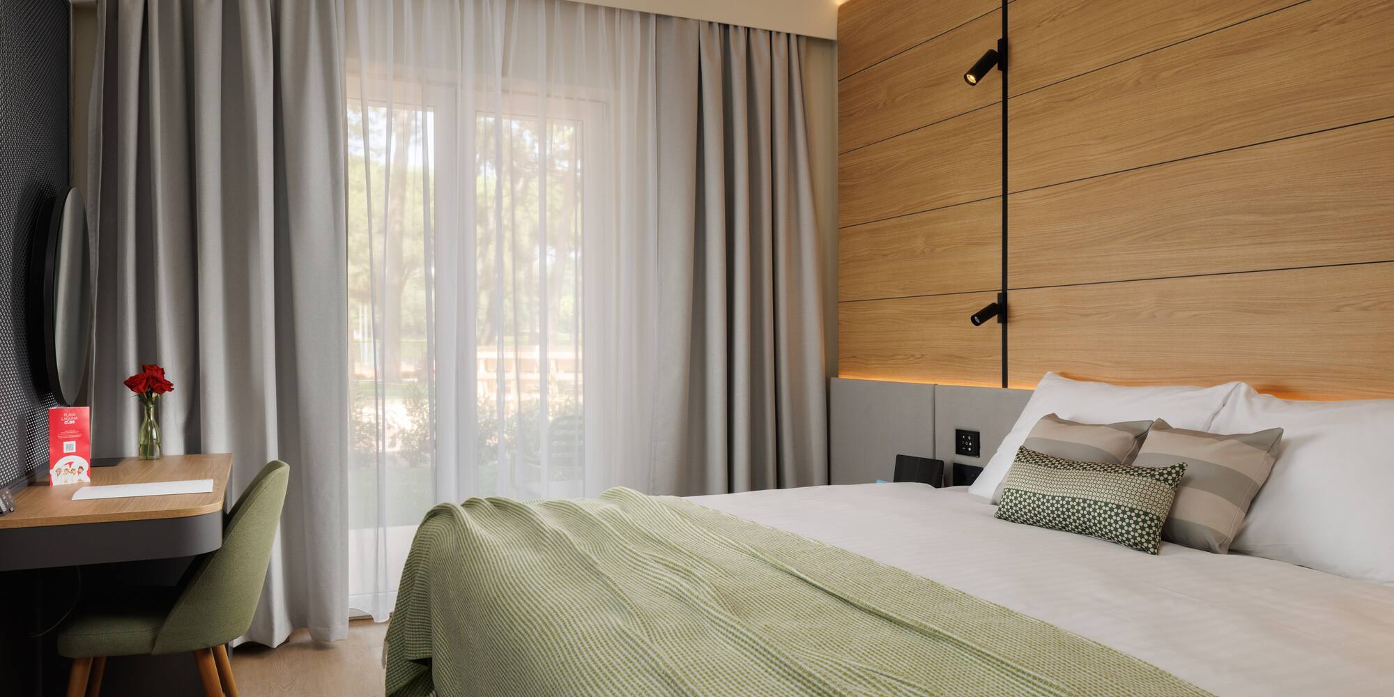 a bed with a green blanket and a wood paneled wall