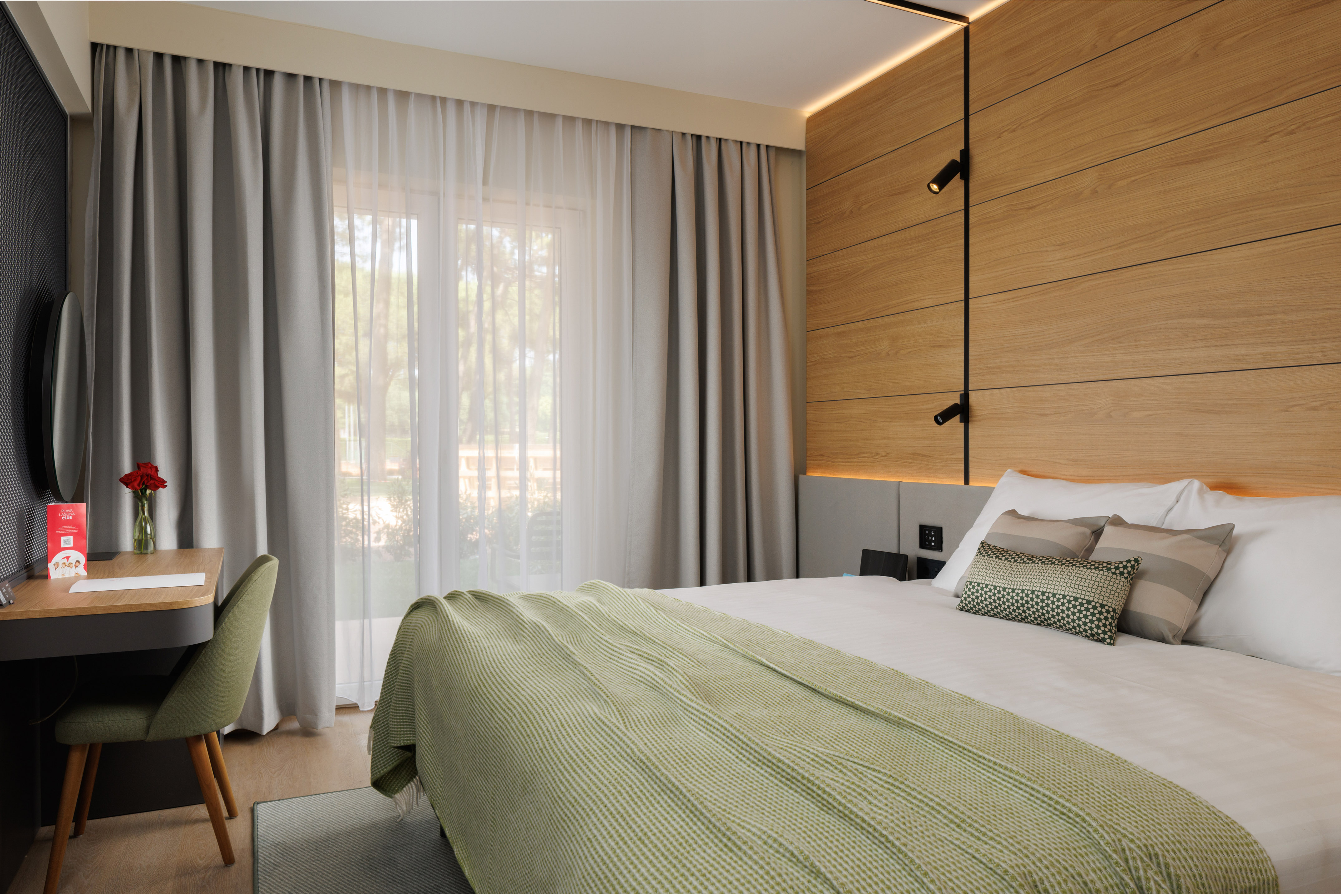 a bed with a green blanket and a wood paneled wall