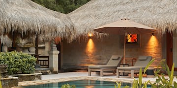 a pool and lounge chairs in a resort
