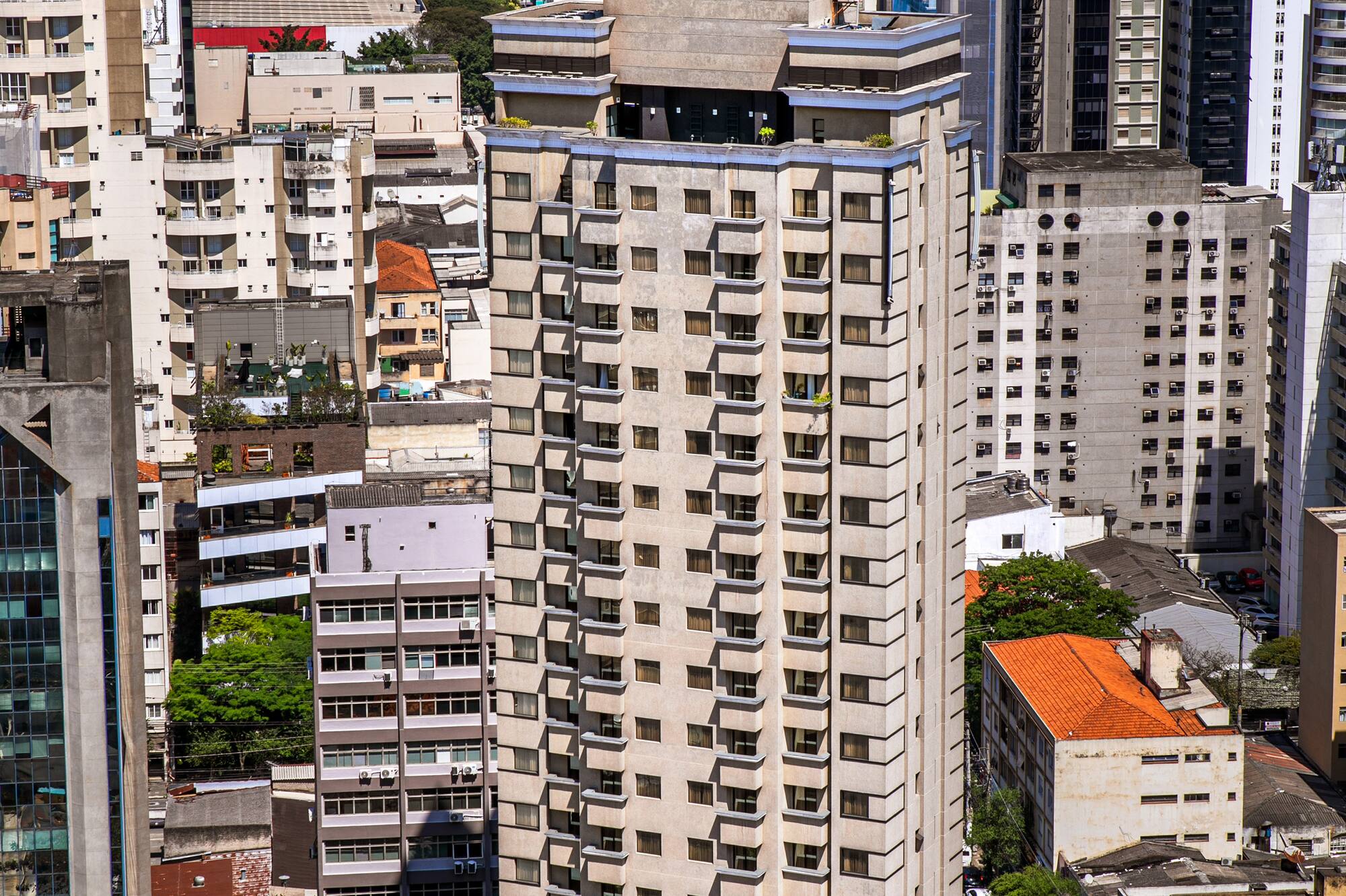 São Paulo high-rise building with a rooftop clock in urban landscape.
