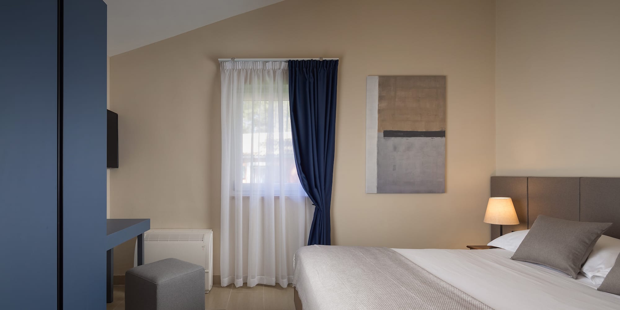 a bedroom with a bed and a blue curtain