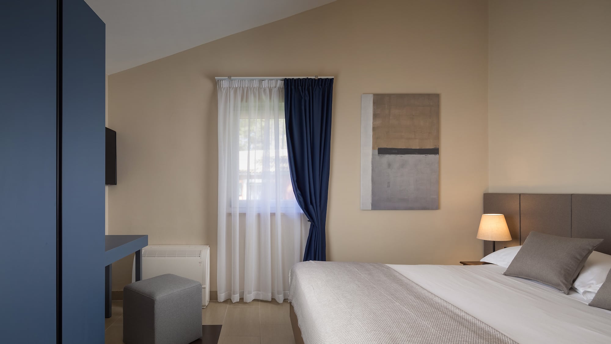 a bedroom with a bed and a blue curtain